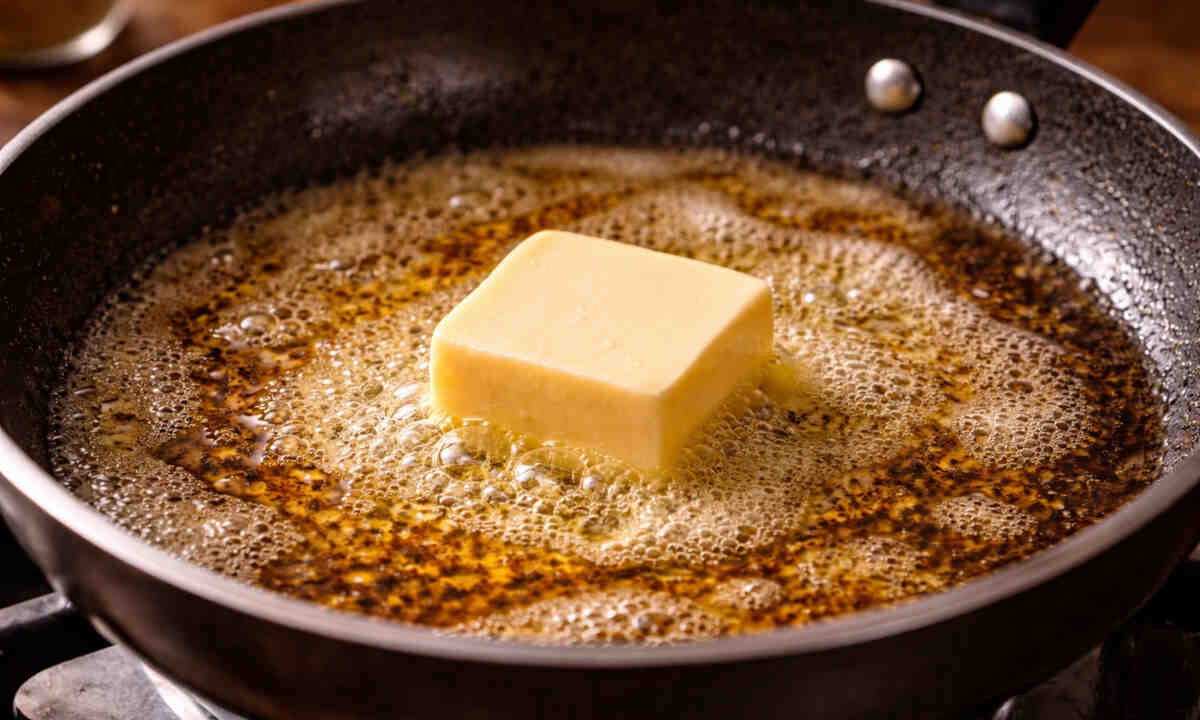Pezzo di burro che si sta sciogliendo in padella