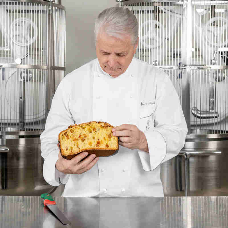 Primo piano del maestro pasticcere Iginio Massari con in mano una colomba pasquale