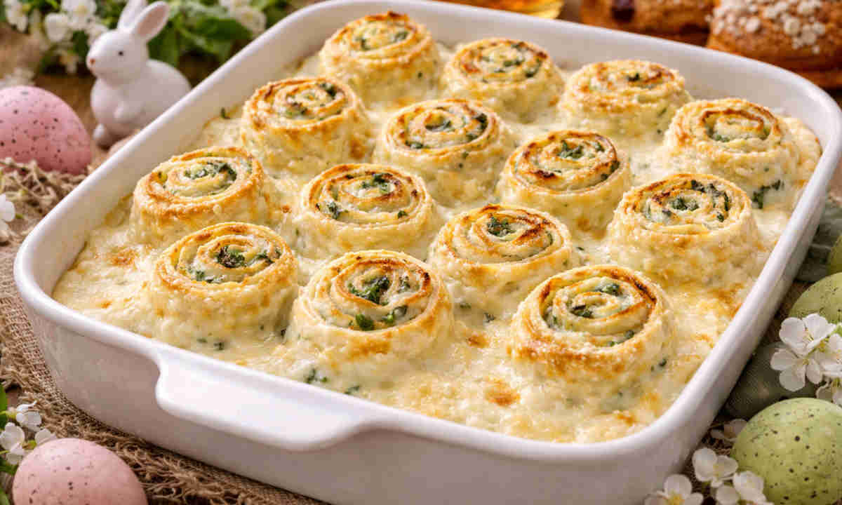 Pirofila da forno su tavola pasquale con all'interno delle crespelle ricotta e spinaci condite con besciamella densa