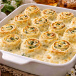 Pirofila da forno su tavola pasquale con all'interno delle crespelle ricotta e spinaci condite con besciamella densa