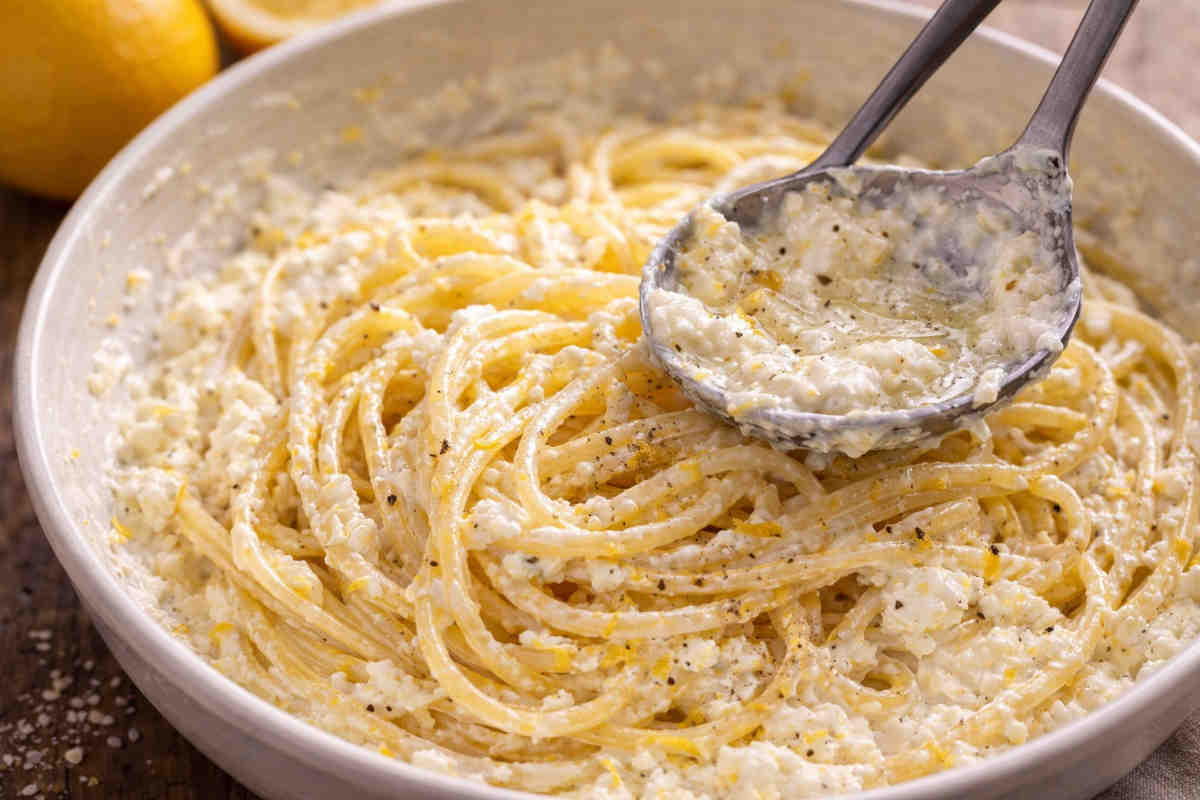 Primo piano di una pasta cremosa con ricotta e limone