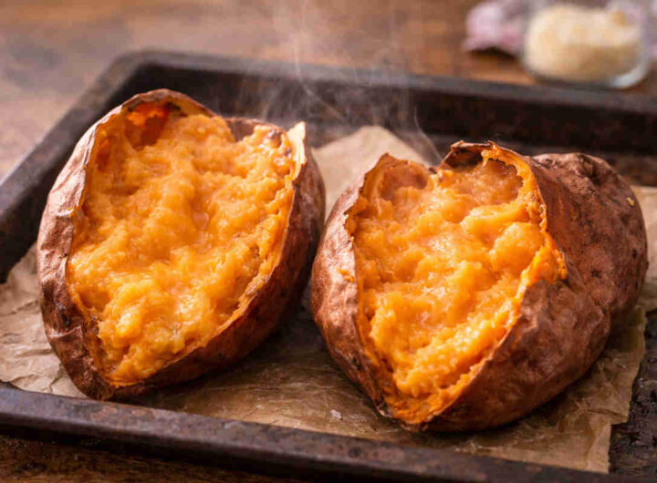 Teglia da forno con carta forno e sopra delle patate dolci cremose appena sfornate