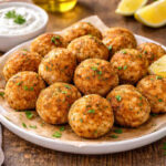 Piatto da portata su tavolo di legno con all'interno delle polpette di pesce croccanti fuori e morbide dentro